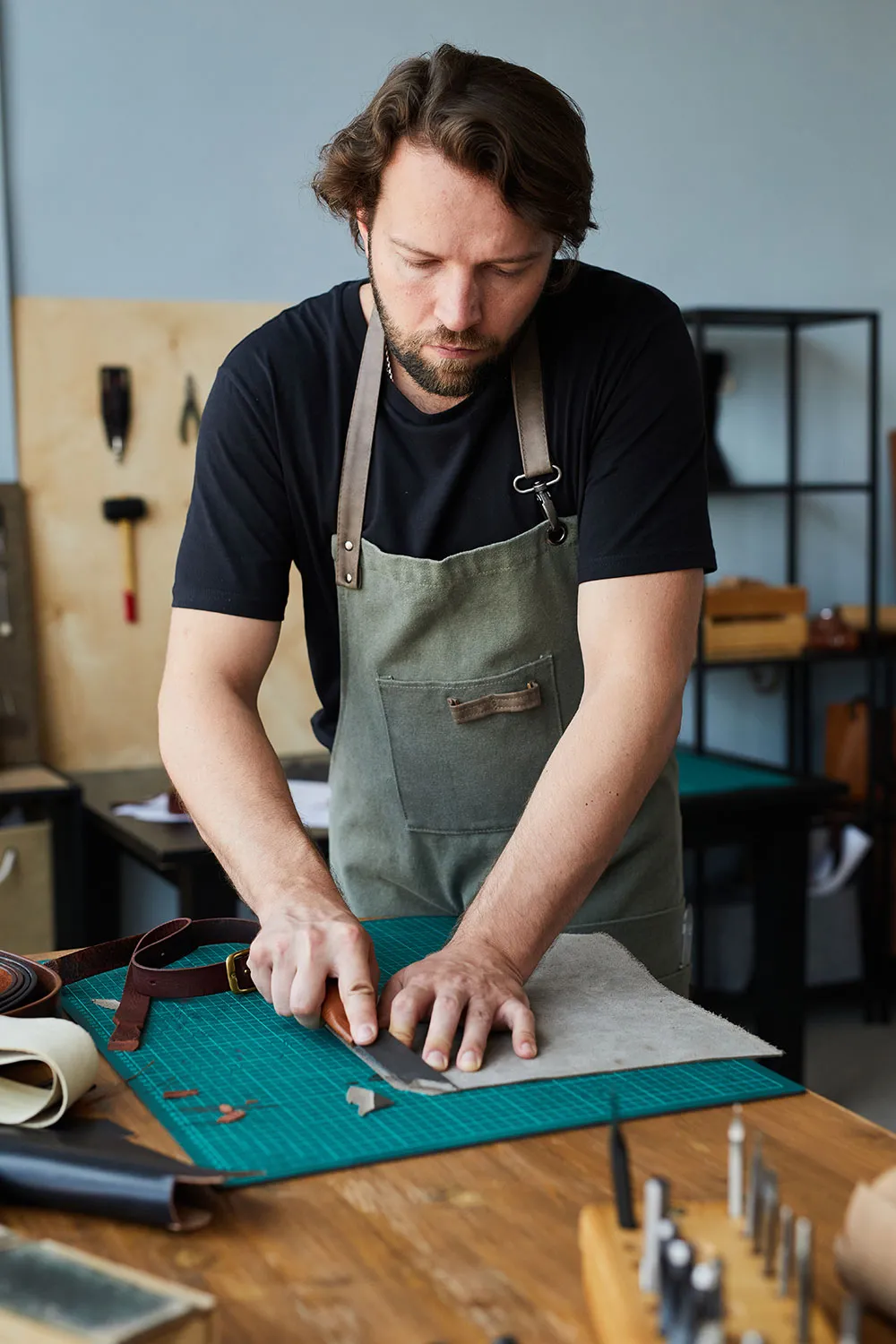 Artisan fabriquant une ceinture en cuir à la main