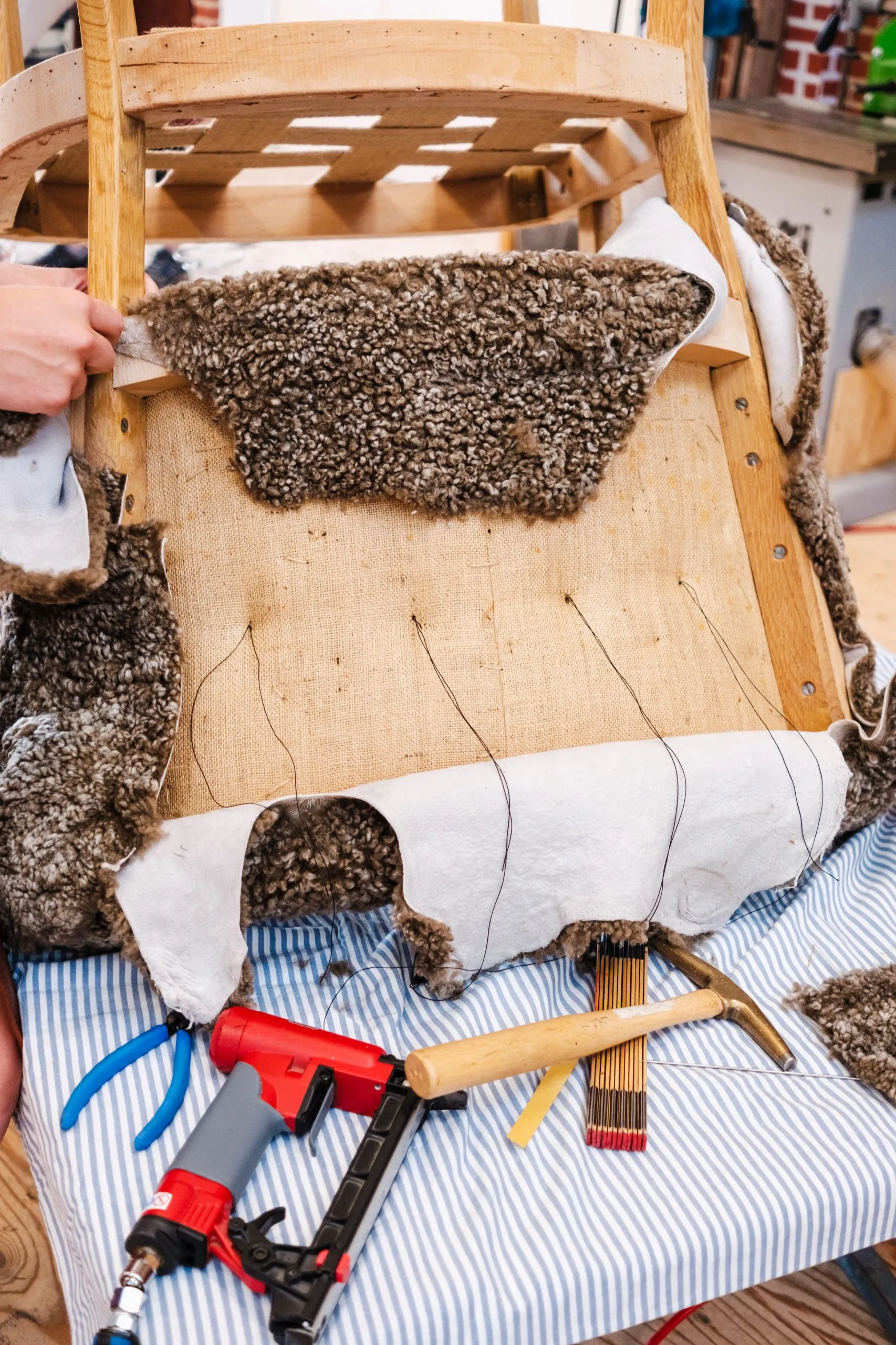 Fauteuil ancien dégarni en cours de réparation dans un atelier de tapisserie