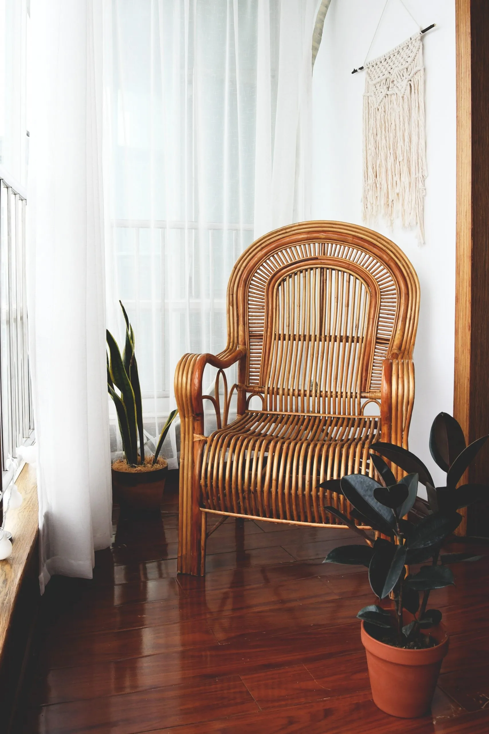 Chaise à bascule en bois avec assise et dossier cannés près d'une fenêtre