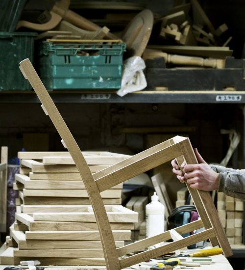 Artisan travaillant une pièce de bois dans un atelier de fabrication de meubles