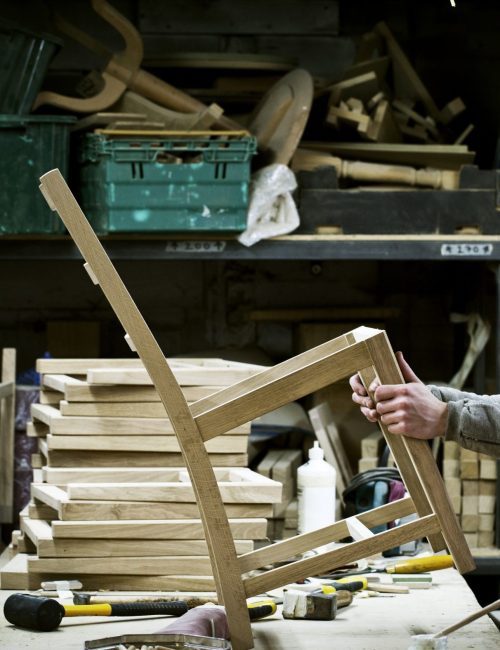 Artisan travaillant une pièce de bois dans un atelier de fabrication de meubles