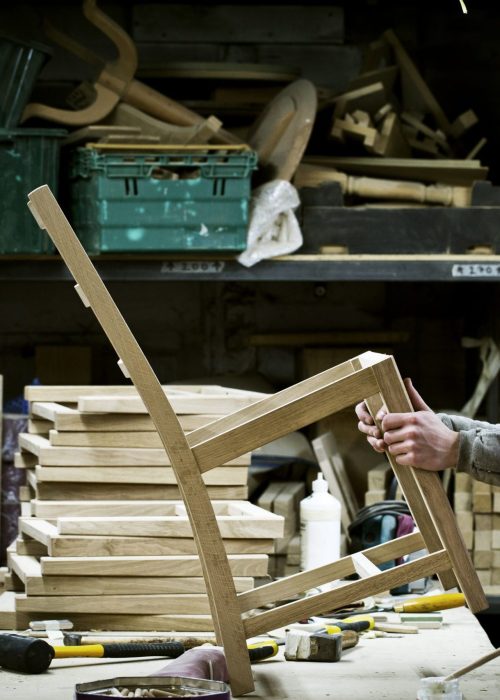Artisan travaillant une pièce de bois dans un atelier de fabrication de meubles