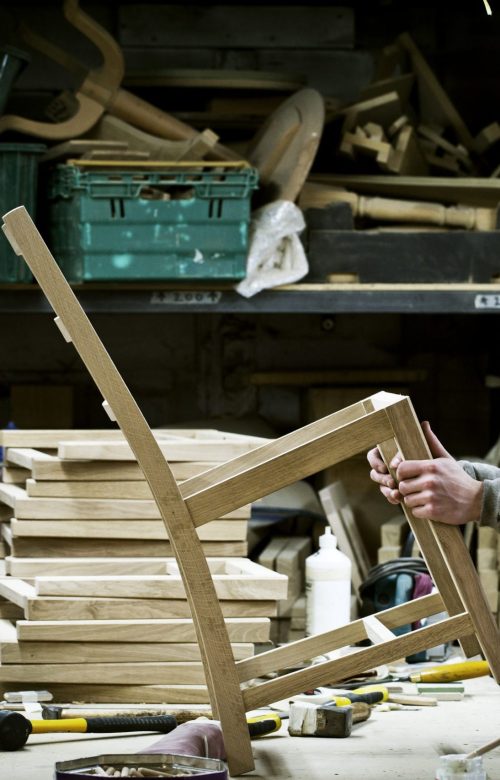 Artisan travaillant une pièce de bois dans un atelier de fabrication de meubles
