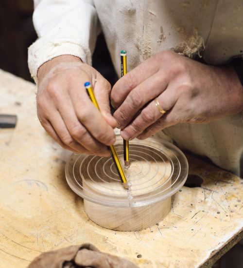 Ébéniste marquant au crayon une planche de bois avant découpe