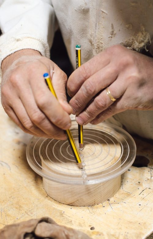 Ébéniste marquant au crayon une planche de bois avant découpe