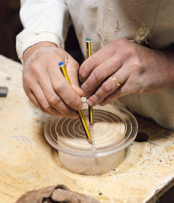 Ébéniste marquant au crayon une planche de bois avant découpe
