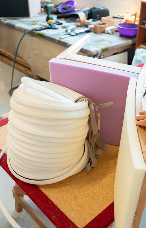 Tapissier posant la garniture d'un siège dans son atelier