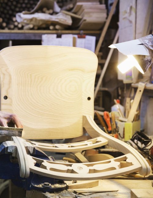 Artisan debout à son établi dans un atelier de menuiserie
