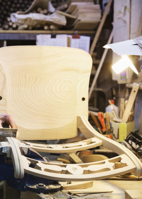 Artisan debout à son établi dans un atelier de menuiserie