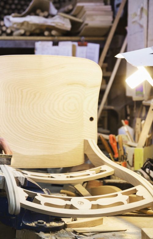 Artisan debout à son établi dans un atelier de menuiserie