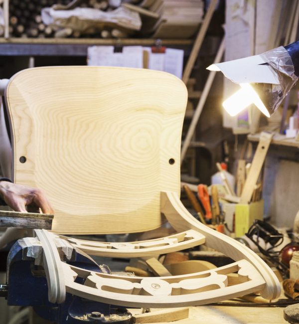 Artisan debout à son établi dans un atelier de menuiserie