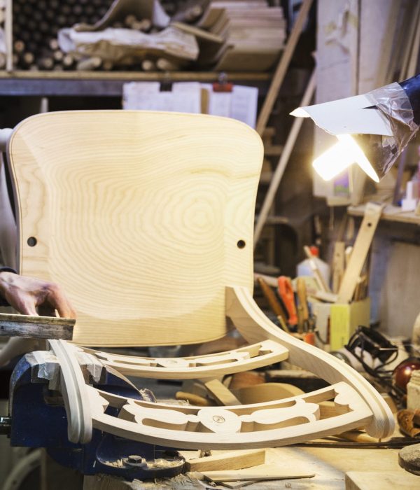 Artisan debout à son établi dans un atelier de menuiserie
