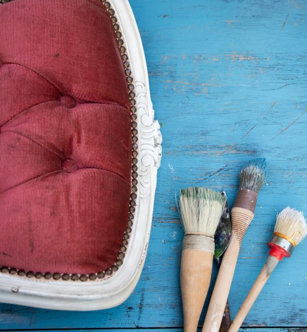 Application de peinture à la brosse sur un meuble en bois en extérieur