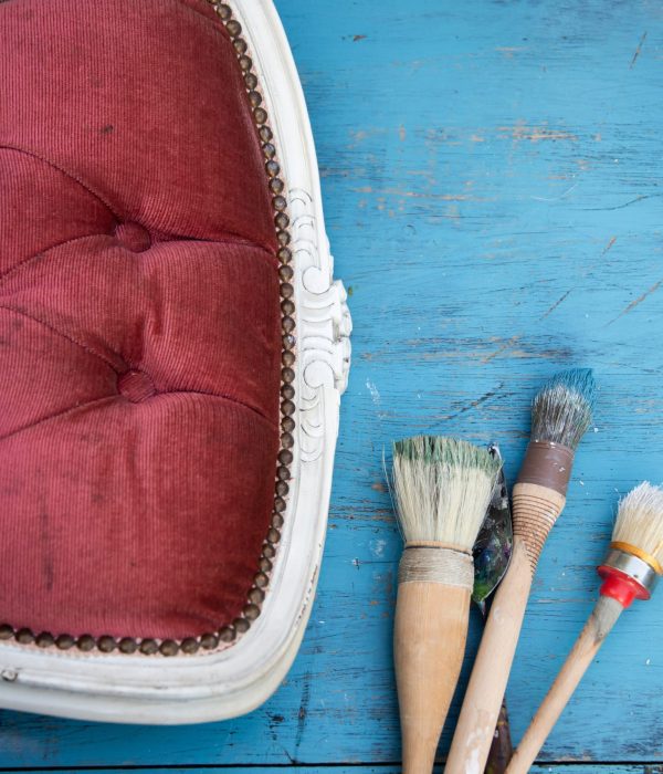 Application de peinture à la brosse sur un meuble en bois en extérieur